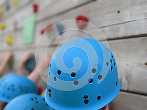 Children wearing blue climbing helmets on a climbing wall