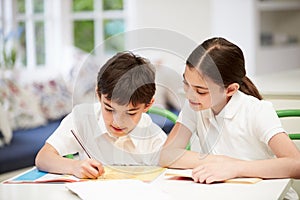 Children Wearing Doing Homework In Kitchen