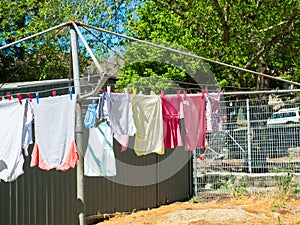 Children Wet clothes hanging on a backyard washing line in the sundry.