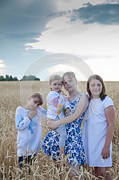 Children in   wheat field.  Girls stand side by side in nature