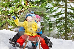 Children winter fun on sledge sliding down