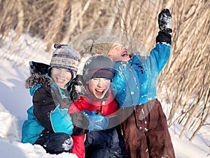 Children in winterwear laughing while playing in snowdrift