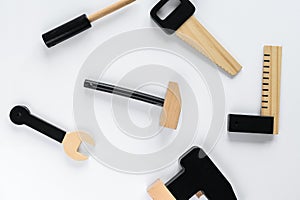 Children wooden instruments on a white  background, a hammer in the center of the composition. The concept of diy