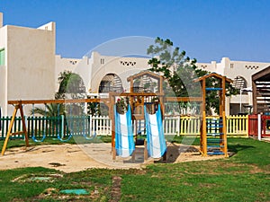 Children wooden playground with slides and swings