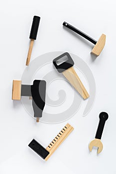 Children wooden tools on white background.  The concept of diy. Saw, drill, screwdriver, hammer, key hexagon