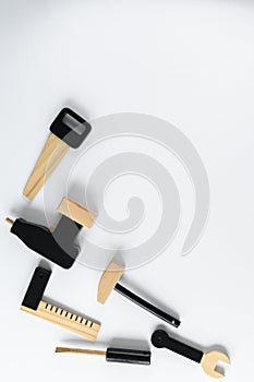 Children wooden tools on white  background, space for text. The concept of diy. Saw, drill, screwdriver, hammer, key hexagon