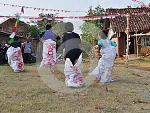 Childrens competiting in sack race. Celebration to welcome Independence day of Indonesia