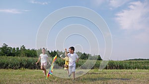 Childrens entertainment, happy childs have fun running to play with kite in clearing during summer holidays on