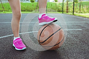 Childrens feet and a basketball ball close-up. Healthy lifestyle and sport concepts