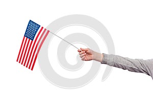 Childrens hand holds the flag of USA isolated on white background. Flag of United States of America