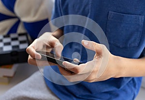 Childrens hands with mobile phone playing video games.