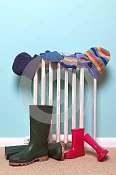 Childrens hats, gloves and wellies by radiator photo