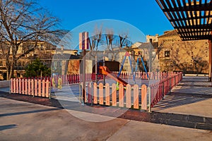 Childrens playground with swings and slides dawning in Corralillo de San Miguel in Toledo, Castilla La Mancha, Spain