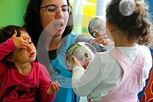 Childrens playing with teacher at Kindergarten in classroom