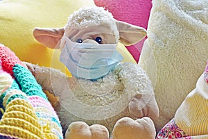 A childrens plush stuffed animal toy wearing a face mask