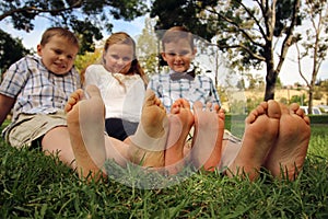 Childrens with their feet toether in the grass photo