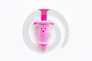 Childrens toy syringe pink isolated object on white background