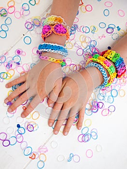 Childs arms wearing multicoloured bracelets