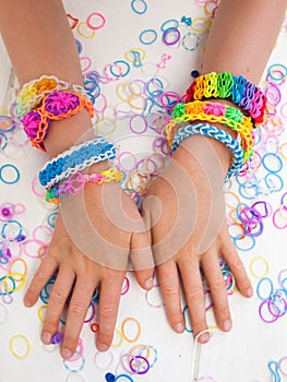 Childs arms wearing multicoloured bracelets