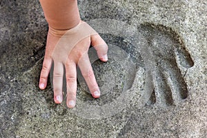 Childs hand and memorable handprint in concrete