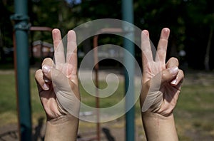 Childs hands making peace signs