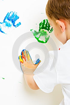 Childs messy painted hands on the wall