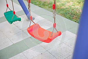 Plastic and Empty red and green chain swings in children playground. chain swings hanging in garden . Childs swing in a park