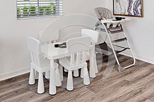 Childs table and highchair in corner of room