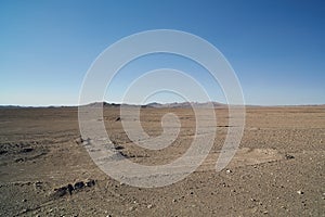 Chile, Atacama desert - view of desert with hills in the back and tracks of industrial activity