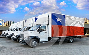 Chile flag on the back of Five new white trucks against the backdrop of the river and the city. Truck, transport, freight