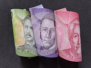 Chilean banknotes of different denominations and black background