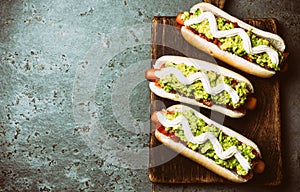 Chilean Completo Italiano. Hot dog sandwiches with tomato, avocado and mayonnaise on wooden board. Top view, copy space photo