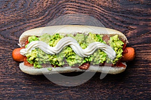 Chilean Completo Italiano. Hot dog sandwiches with tomato, avocado and mayonnaise on wooden board. Top view, copy space