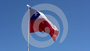 Chilean flag flies in light breeze facing right - slow motion