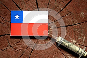 Chilean flag on a stump with syringe injecting money