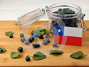 Chilean flag on a wooden plank with blueberries on whit