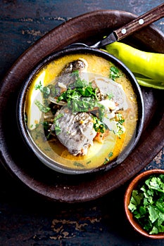 CHILEAN FOOD. Fish soup CALDILLO DE CONGRIO served in clay bowl, top view