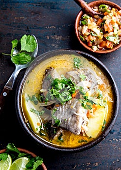 CHILEAN FOOD. Fish soup CALDILLO DE CONGRIO served in clay bowl, top view