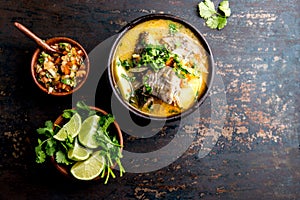 CHILEAN FOOD. Fish soup CALDILLO DE CONGRIO served in clay bowl, top view. copy space