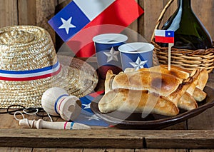 Chilean independence day concept. fiestas patrias. Tipical baked empanadas de pino, wine or chicha, hat and play emboque. Dish and photo