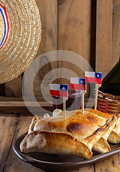 Chilean independence day concept. fiestas patrias. Tipical baked empanadas de pino, wine or chicha, hat and play emboque photo