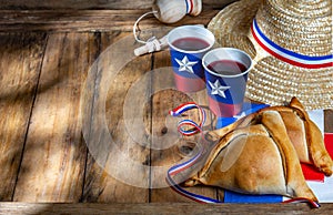 Chilean independence day concept. fiestas patrias. Tipical baked empanadas, wine or chicha, fat and play emboque. Decoration for photo