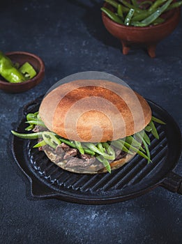 Chilean Latin american sandwich burger Chacarero with premium beef slices and green bean on black background.