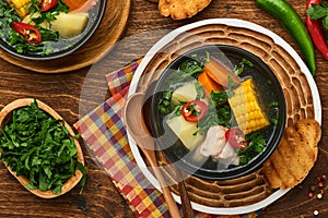 Chilean meat soup with pampkin, corn, fresh coriander and potatoes on old wooden table background. Cazuela. Latinamerican food