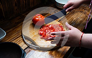 Chilean Pebre sauce preparation, dicing tomatos photo