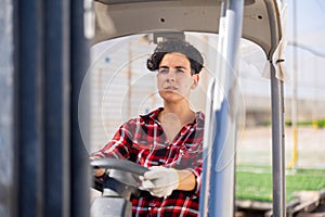 Chilean woman forklift worker operator driving vehicle at greenhouse