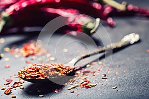 Chili. Chili peppers. Several dried chilli peppers and crushed peppers on an old spoon spilled around. Mexican ingredients