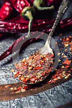 Chili. Chili peppers. Several dried chilli peppers and crushed peppers on an old spoon spilled around. Mexican ingredients