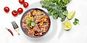 Chili con carne with beef, red beans, paprika, corn and hot peppers in tomato sauce, spicy tex-mex dish, white table background,