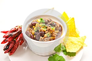 Chili con carne in a clay bowl on a white bright background- traditional dish of mexican cuisine.
